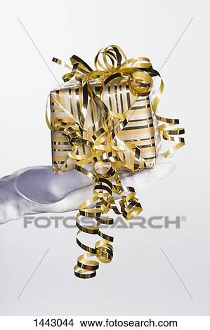 Picture - Cropped hand of bride holding gift box against white background. Fotosearch