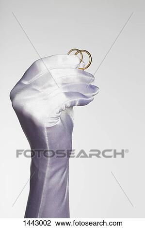 Cropped hand of bride holding wedding rings against white background View Large Photo Image Stock Image - Cropped hand of bride holding wedding rings against white background. Fotosearch
