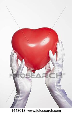 Cropped hands of bride holding heart shape balloon against white background View Large Photo Image Stock Image - Cropped hands of bride holding heart shape balloon against white background. Fotosearch