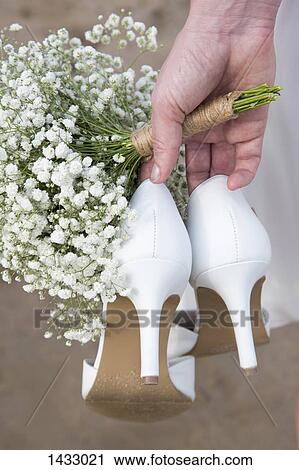 Cropped image of bride holding high heels and flowers View Large Photo Image Stock Image - Cropped image of bride holding high heels and flowers. Fotosearch