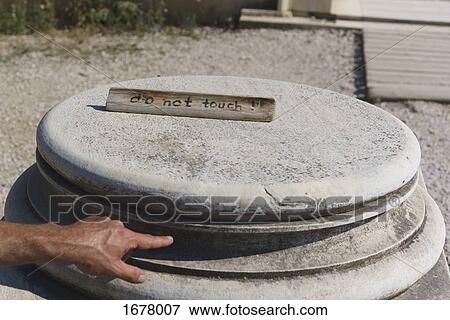 Cropped image of man's hand pointing at stone object with text on sunny day View Large Photo Image Stock Photo - Cropped image of man's hand pointing at stone object with text on sunny day. Fotosearch