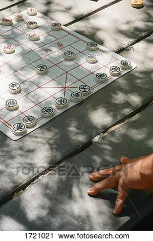 Cropped image of person with Chinese chess on table View Large Photo Image Stock Image - Cropped image of person with Chinese chess on table. Fotosearch