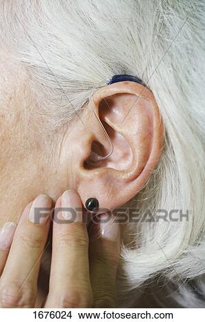 Cropped image of senior woman wearing hearing aid View Large Photo Image Picture - Cropped image of senior woman wearing hearing aid. Fotosearch