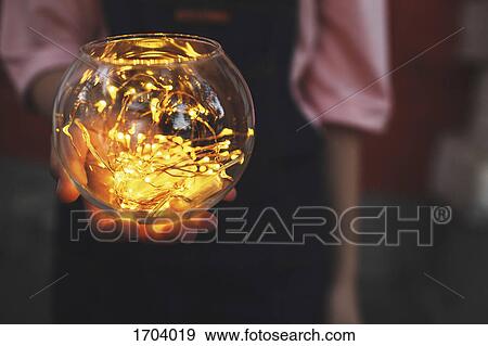 Cropped image of teenage girl holding illuminated string lights in glass bowl View Large Photo Image Stock Photo - Cropped image of teenage girl holding illuminated string lights in glass bowl. Fotosearch