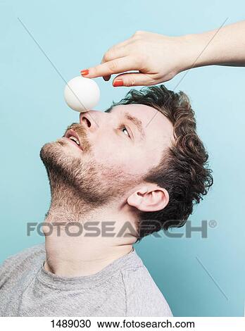 Cropped image of woman balancing egg on man's nose View Large Photo Image Stock Image - Cropped image of woman balancing egg on man's nose. Fotosearch
