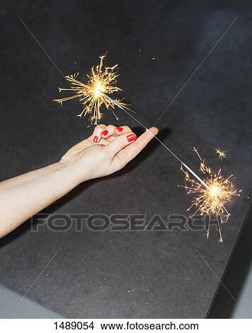 Cropped image of woman balancing sparklers on fingers View Large Photo Image Picture - Cropped image of woman balancing sparklers on fingers. Fotosearch