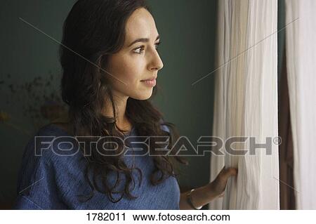 Curious woman standing at window, waiting View Large Photo Image Stock Image - Curious woman standing at window, waiting. Fotosearch