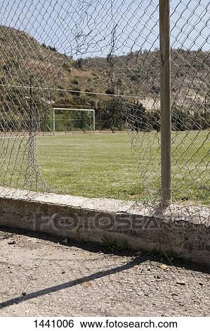Damaged chainlink fence against soccer field View Large Photo Image Stock Photograph - Damaged chainlink fence against soccer field. Fotosearch