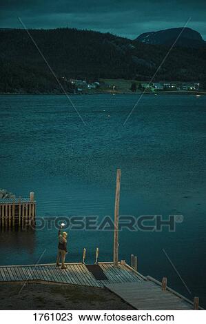 Detail of person standing on jetty by water, Gros Morne, Newfoundland, Canada View Large Photo Image Stock Image - Detail of person standing on jetty by water, Gros Morne, Newfoundland, Canada. Fotosearch