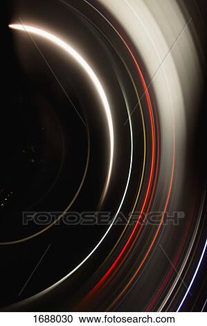 Stock Image - Directly above full frame shot of abstract light trails against black background. Fotosearch