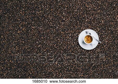 Stock Image - Directly above shot of espresso cup on roasted coffee beans. Fotosearch