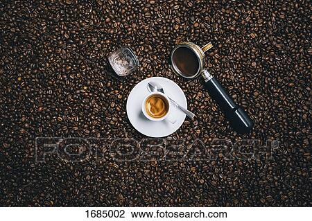 Stock Image - Directly above shot of espresso cup with filter on roasted coffee beans. Fotosearch