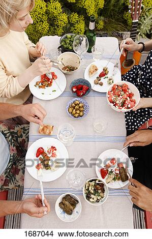 Picture - Directly above shot of male and female friends having lunch at outdoor table. Fotosearch