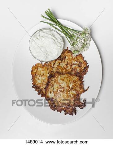 Directly above shot of potato pancakes and sour cream in plate over white background View Large Photo Image Picture - Directly above shot of potato pancakes and sour cream in plate over white background. Fotosearch