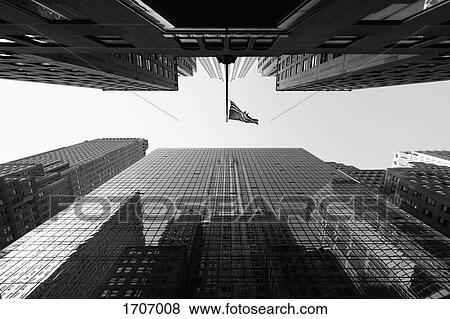 Directly below view of American Flag amidst skyscrapers against sky, New York City, New York, USA View Large Photo Image Stock Photo - Directly below view of American Flag amidst skyscrapers against sky, New York City, New York, USA. Fotosearch