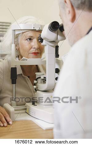 Doctor examining senior woman's eye at clinic View Large Photo Image Stock Image - Doctor examining senior woman's eye at clinic. Fotosearch