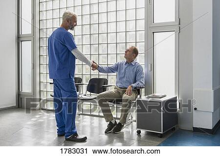 Doctor greeting, shaking hands with patient in clinic waiting room View Large Photo Image Stock Image - Doctor greeting, shaking hands with patient in clinic waiting room. Fotosearch