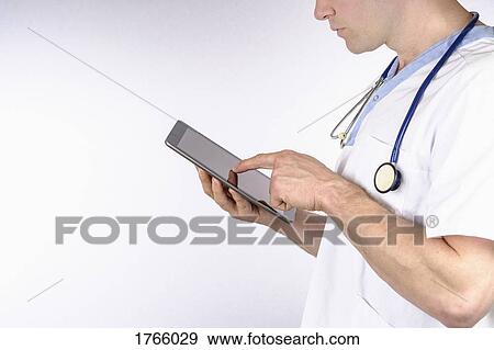 Stock Photo - Doctor using digital tablet against white background. Fotosearch