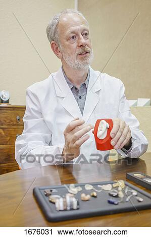 Doctor with anatomical model and hearing aids explaining at table in clinic View Large Photo Image Stock Image - Doctor with anatomical model and hearing aids explaining at table in clinic. Fotosearch