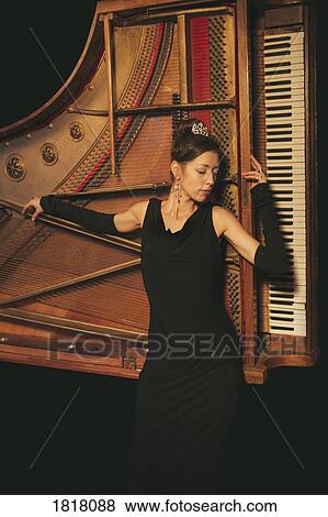 Elegant, well-dressed woman laying on piano View Large Photo Image Stock Photo - Elegant, well-dressed woman laying on piano. Fotosearch