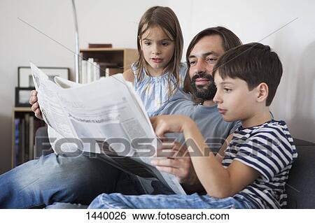 Father and children reading newspaper on sofa at home View Large Photo Image Stock Photograph - Father and children reading newspaper on sofa at home. Fotosearch