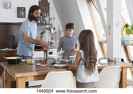 Father and children setting table for lunch in kitchen View Large Photo Image Picture - Father and children setting table for lunch in kitchen. Fotosearch