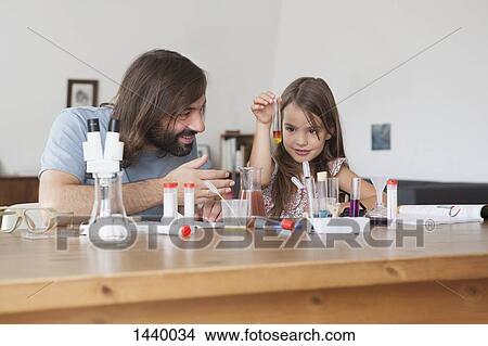 Father and daughter doing science experiment at home View Large Photo Image Picture - Father and daughter doing science experiment at home. Fotosearch