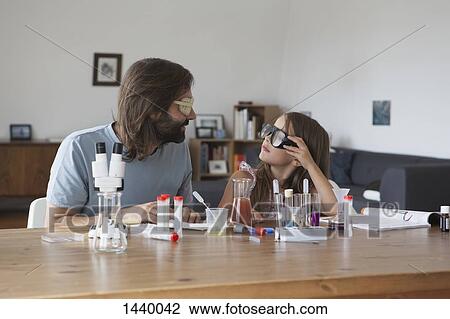 Father and daughter doing science experiment at table View Large Photo Image Stock Image - Father and daughter doing science experiment at table. Fotosearch