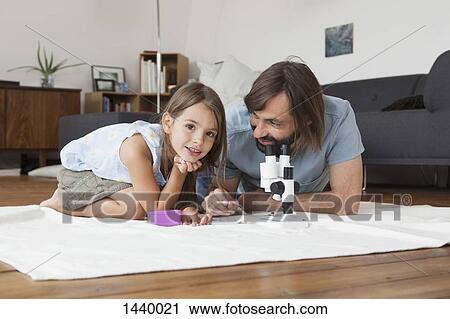 Father and daughter using microscope on carpet at home View Large Photo Image Stock Image - Father and daughter using microscope on carpet at home. Fotosearch