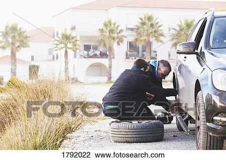 Father and son changing car tire at roadside View Large Photo Image Stock Image - Father and son changing car tire at roadside. Fotosearch