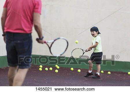 Father and son playing tennis on field View Large Photo Image Stock Image - Father and son playing tennis on field. Fotosearch