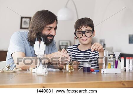 Father and son working on school science project at home View Large Photo Image Stock Image - Father and son working on school science project at home. Fotosearch