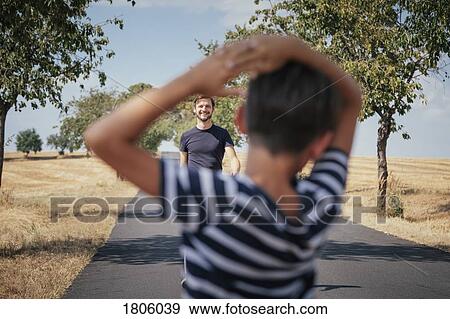 Father approaching sun on rural road View Large Photo Image Stock Photo - Father approaching sun on rural road. Fotosearch