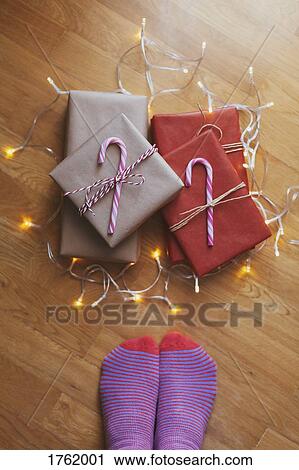 Feet with striped socks standing next to a stack of wrapped and decorated Christmas presents View Large Photo Image Stock Image - Feet with striped socks standing next to a stack of wrapped and decorated Christmas presents. Fotosearch