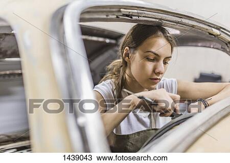 Female mechanic repairing car at garage View Large Photo Image Stock Image - Female mechanic repairing car at garage. Fotosearch