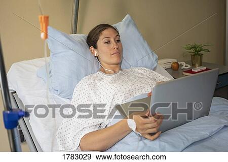 Female patient using laptop, resting and recovering in hospital room View Large Photo Image Stock Photo - Female patient using laptop, resting and recovering in hospital room. Fotosearch