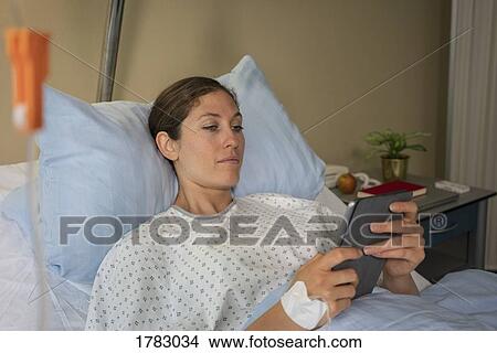 Female patient with digital tablet resting, recovering in hospital bed View Large Photo Image Picture - Female patient with digital tablet resting, recovering in hospital bed. Fotosearch