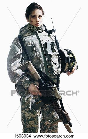 Female soldier holding rifle and helmet while standing against white background View Large Photo Image Picture - Female soldier holding rifle and helmet while standing against white background. Fotosearch