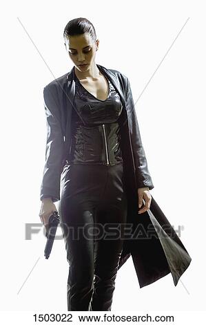 Female spy holding gun while walking against white background View Large Photo Image Stock Image - Female spy holding gun while walking against white background. Fotosearch