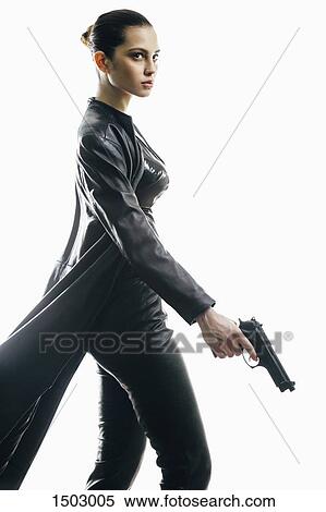 Stock Photography - Female spy with gun walking against white background. Fotosearch