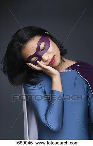 Female superhero napping against gray background View Large Photo Image Stock Photograph - Female superhero napping against gray background. Fotosearch