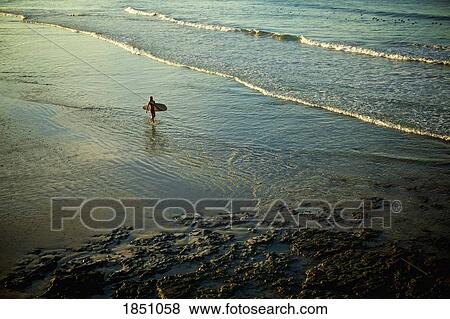 Female surfer carrying surfboard in sunny ocean surf, Punta de Mita, Nayarit, Mexico View Large Photo Image Stock Photo - Female surfer carrying surfboard in sunny ocean surf, Punta de Mita, Nayarit, Mexico. Fotosearch