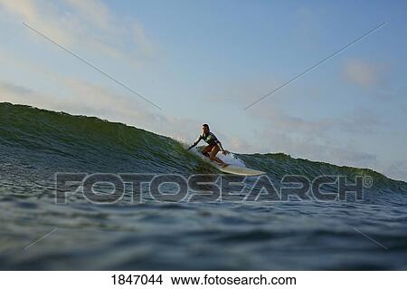 Female surfer riding ocean wave View Large Photo Image Picture - Female surfer riding ocean wave. Fotosearch
