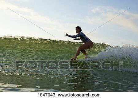 Female surfer riding ocean wave View Large Photo Image Stock Image - Female surfer riding ocean wave. Fotosearch