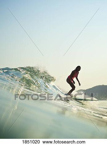 Female surfer riding ocean wave View Large Photo Image Stock Image - Female surfer riding ocean wave. Fotosearch