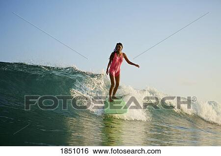 Female surfer riding ocean wave View Large Photo Image Stock Photograph - Female surfer riding ocean wave. Fotosearch