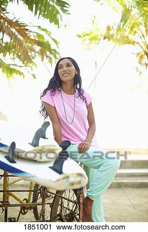 Female surfer sitting next to surfboards View Large Photo Image Stock Image - Female surfer sitting next to surfboards. Fotosearch