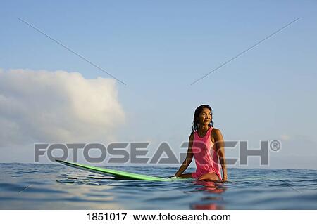 Female surfer waiting on surfboard in ocean View Large Photo Image Stock Photo - Female surfer waiting on surfboard in ocean. Fotosearch