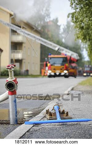 Fire truck tending to apartment fire with open fire hydrant in foreground View Large Photo Image Stock Image - Fire truck tending to apartment fire with open fire hydrant in foreground. Fotosearch