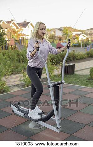 Fit woman using elliptical machine on patio View Large Photo Image Stock Image - Fit woman using elliptical machine on patio. Fotosearch